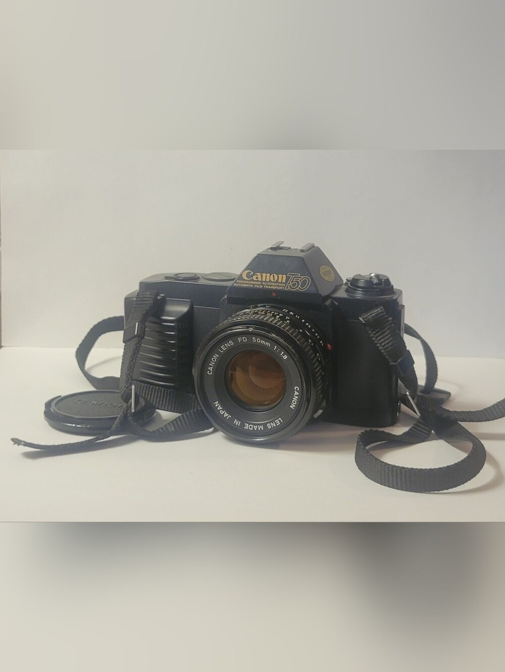 Canon black film camera with 50mm FD f/1.8 lens and neck strap - Picture 1 of 6